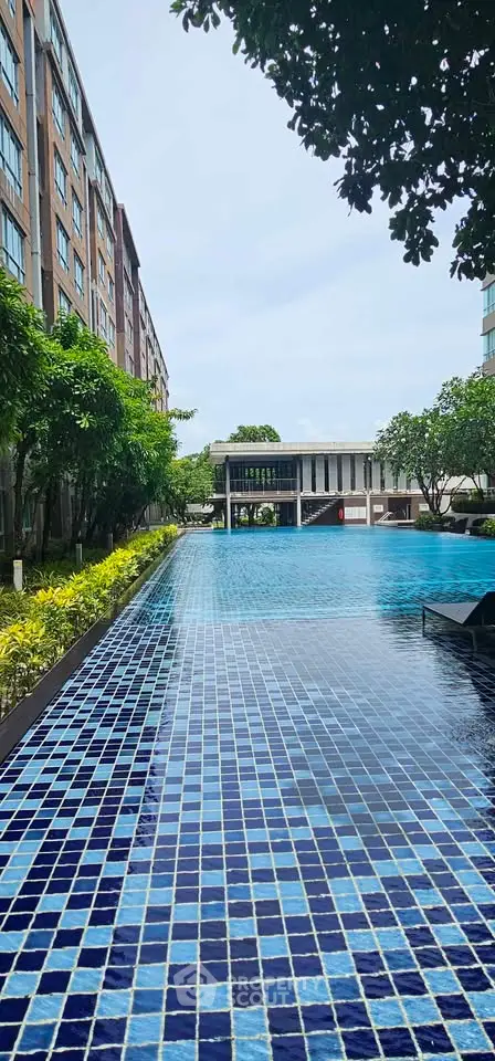 Luxurious apartment complex with stunning outdoor pool and lush greenery, perfect for relaxation and leisure.