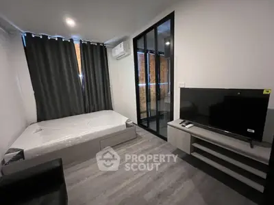 Modern bedroom with large TV and air conditioning in a stylish apartment