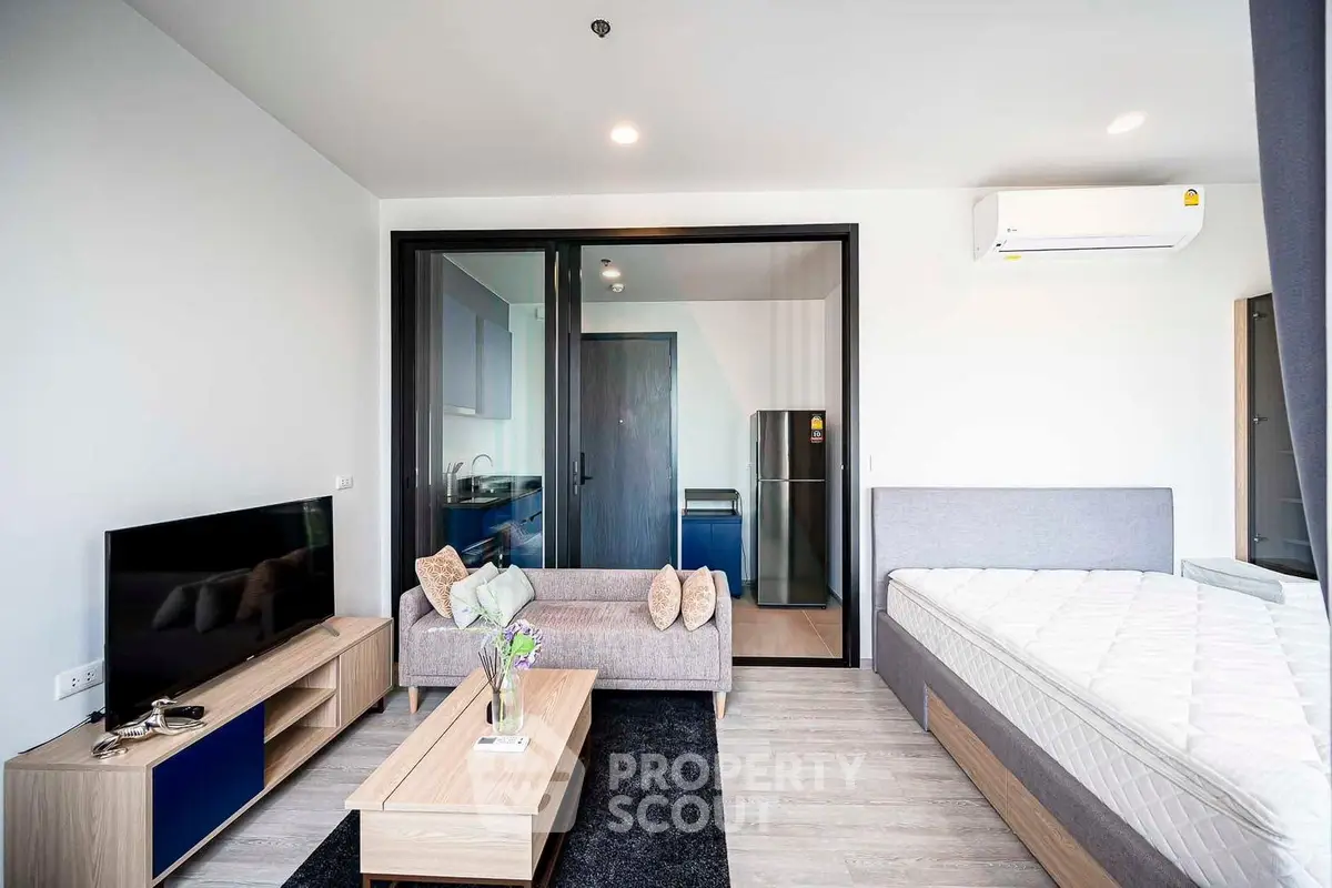 Modern studio apartment with sleek design, featuring a cozy living area, stylish furniture, and a compact kitchen.