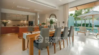 Luxurious open-plan kitchen and dining area with pool view, perfect for entertaining.