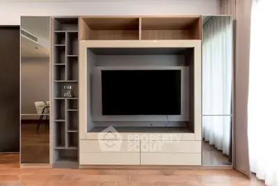 Modern living room with sleek built-in entertainment center and hardwood floors.
