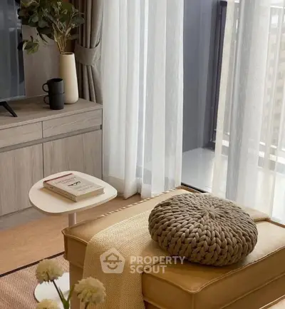 Cozy living room with modern decor and balcony view, featuring elegant furniture and natural light.