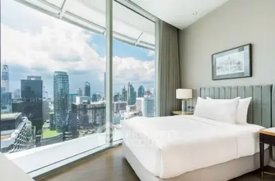 Luxurious bedroom with stunning city view from floor-to-ceiling windows in modern high-rise.