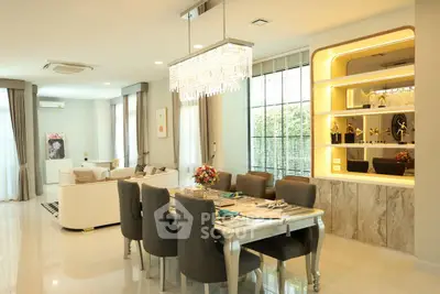 Luxurious open-plan living and dining area with elegant chandelier and modern decor