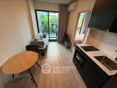 Modern studio apartment with open layout, featuring a cozy living area, compact kitchen, and balcony view.