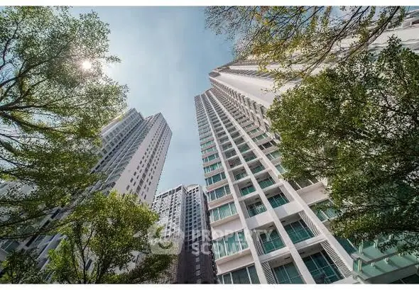 Stunning high-rise residential buildings with lush greenery and clear blue sky.