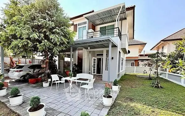 Charming two-story house with spacious patio and lush garden, perfect for family living.