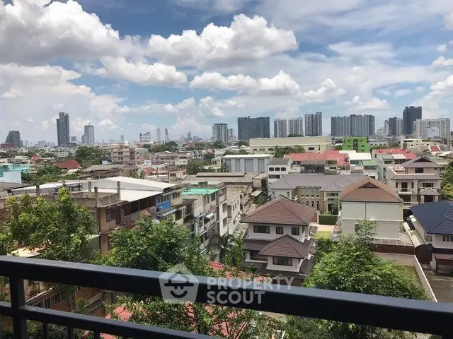 Stunning cityscape view from a balcony overlooking urban skyline and residential area.