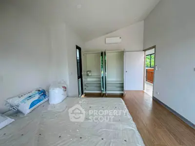 Spacious bedroom with open closet and balcony view, featuring modern design and natural light.