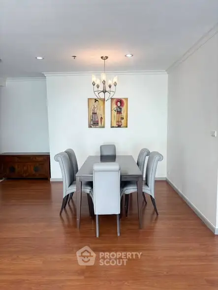 Elegant dining area with modern table and chairs, wooden flooring, and stylish wall art.