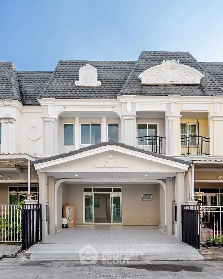 Elegant townhouse exterior with classic architectural details and spacious driveway.