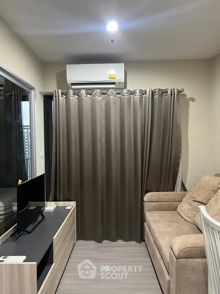 Cozy living room with modern furniture and air conditioning, perfect for relaxation.