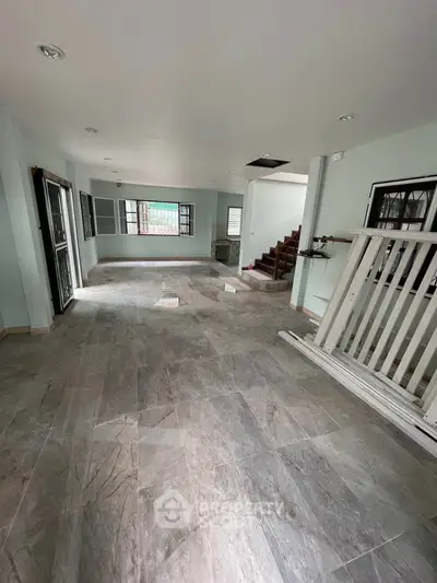 Spacious open-plan living area with tiled flooring and staircase, ideal for modern family living.