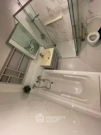 Modern bathroom with sleek fixtures and bathtub in a contemporary apartment.