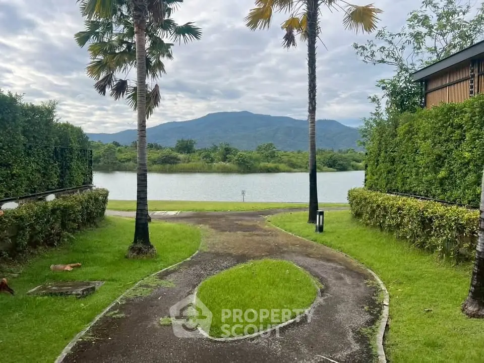 Scenic view of lush garden with mountain backdrop and serene lake, perfect for tranquil living.