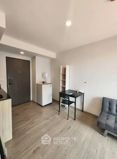 Modern minimalist living room with sleek furniture and wooden flooring.