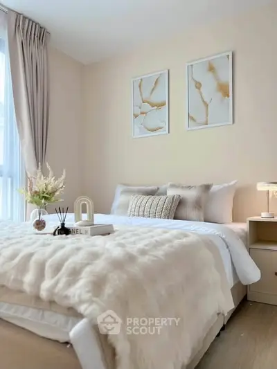 Elegant bedroom with cozy decor and soft lighting, featuring stylish artwork and plush bedding.