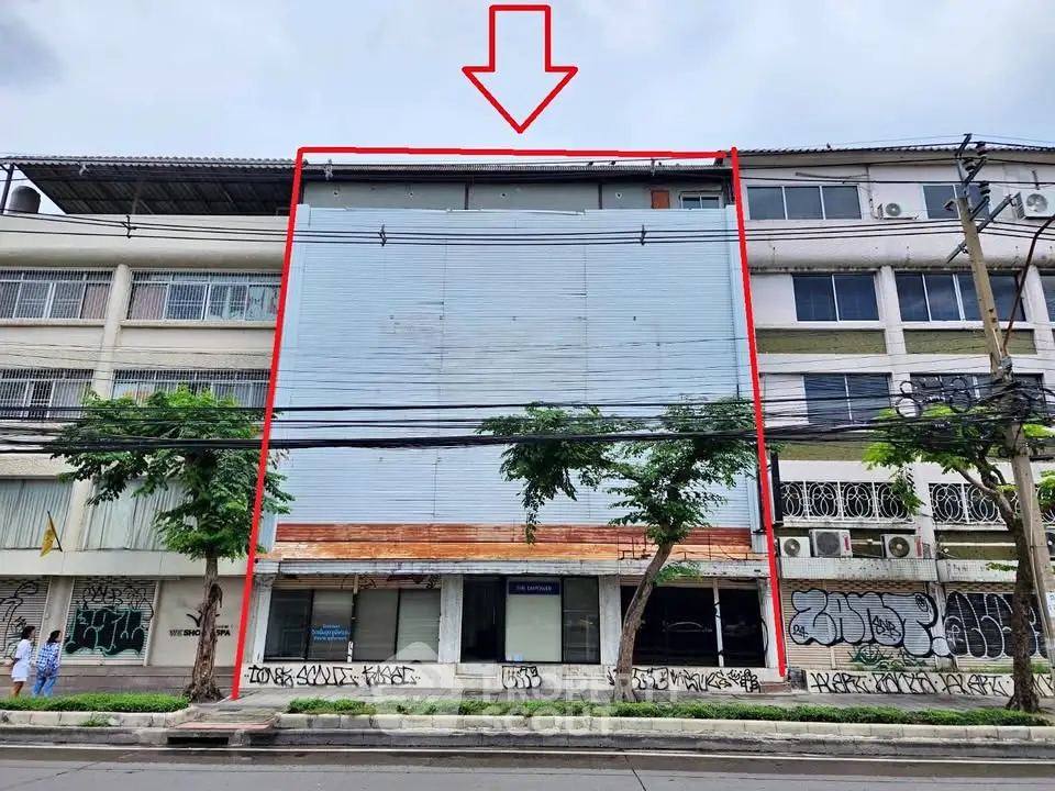 Commercial building with potential for renovation in urban area, featuring graffiti and street view.