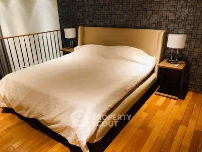 Luxurious bedroom with modern design and elegant lighting, featuring a stylish bed and wooden flooring.