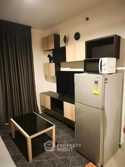 Modern living room with sleek furniture and appliances, featuring a stylish fridge and microwave.