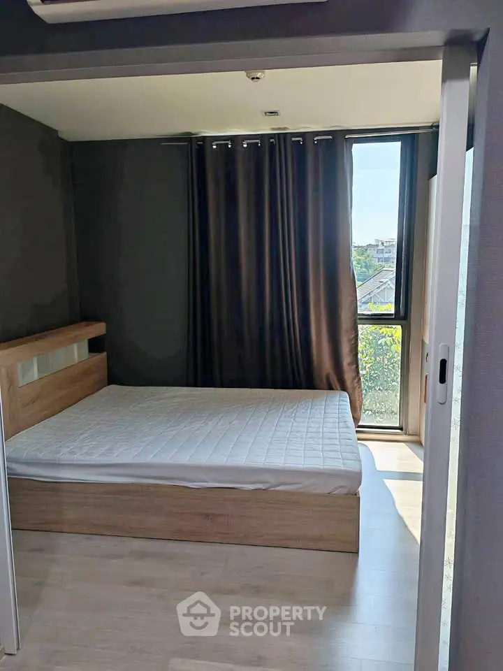 Modern bedroom with large window and wooden flooring