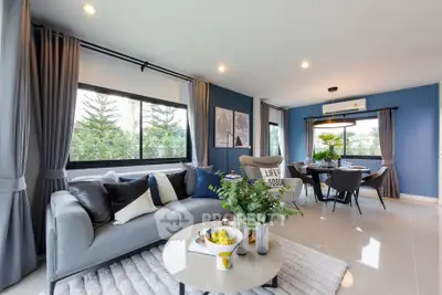 Spacious modern living room with elegant decor and large windows offering lush garden views.