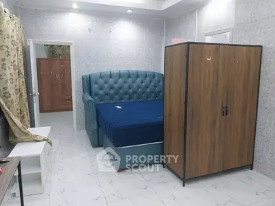 Cozy bedroom with elegant blue bed and wooden wardrobe, perfect for relaxation.