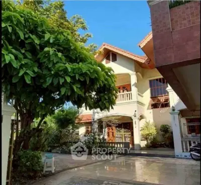 Charming two-story house with lush garden and spacious driveway, perfect for family living.