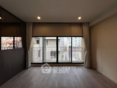 Spacious living room with large windows and city view, perfect for urban living.