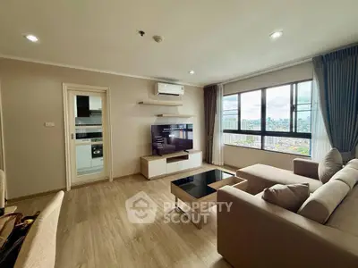 Spacious living room with city view, modern furniture, and natural light.