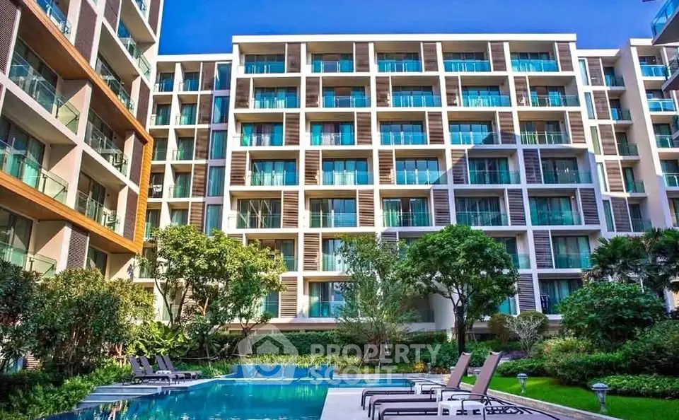 Modern apartment complex with pool and lush greenery, perfect for luxury living.