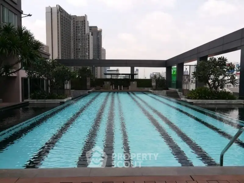 Luxurious rooftop pool with city skyline views in modern residential complex.
