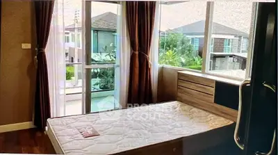 Cozy bedroom with large windows and balcony view in modern home