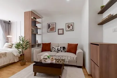 Modern living room with cozy sofa and stylish decor in open-plan apartment.