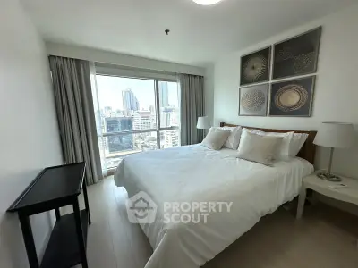 Spacious bedroom with city view, modern decor, and natural light in urban apartment.