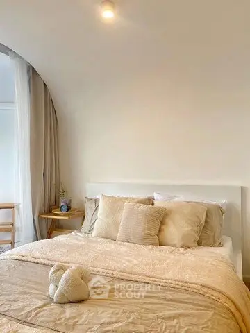 Cozy bedroom with elegant decor and soft lighting, featuring a plush bed and stylish furnishings.