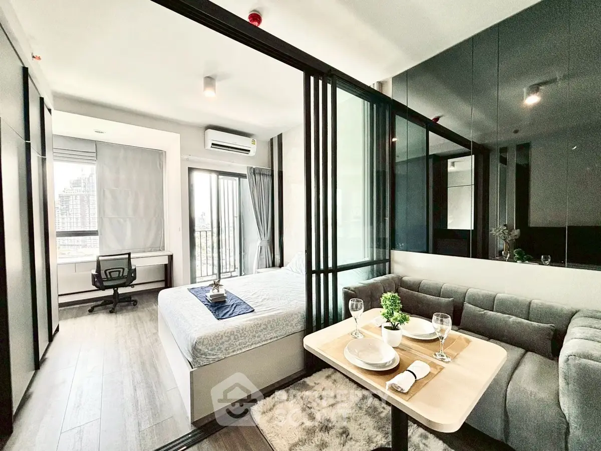 Modern studio apartment with glass partition, cozy living area, and city view, perfect for urban living.