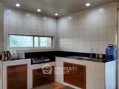Modern kitchen with sleek cabinets and appliances, featuring a gas stove and ample natural light.