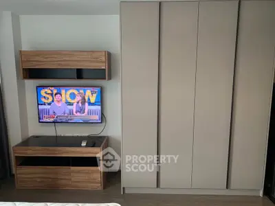 Modern bedroom with sleek wardrobe and mounted TV unit, perfect for stylish living.