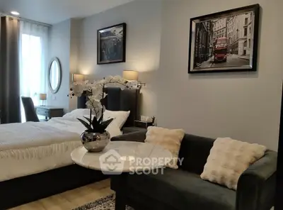 Elegant bedroom with cozy seating area and stylish decor in modern apartment.