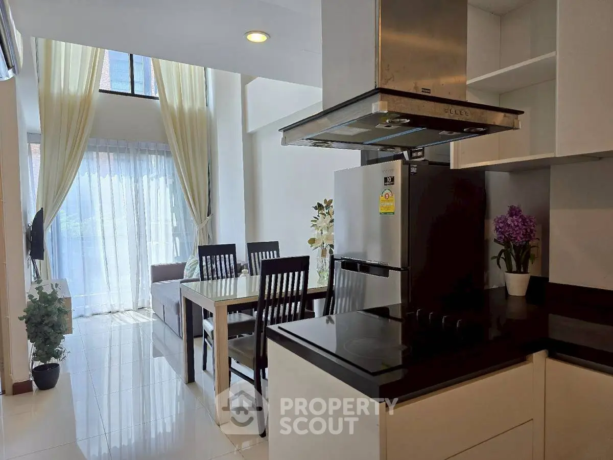 Modern open-layout kitchen and dining area with natural light and stylish decor.