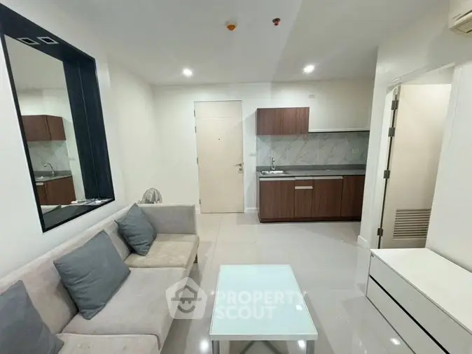 Sleek modern apartment featuring a bright living room with plush seating and a fully equipped kitchen with stylish cabinetry and countertops.