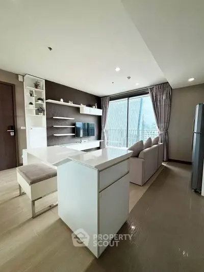 Modern living room with sleek furniture and city view through large windows.
