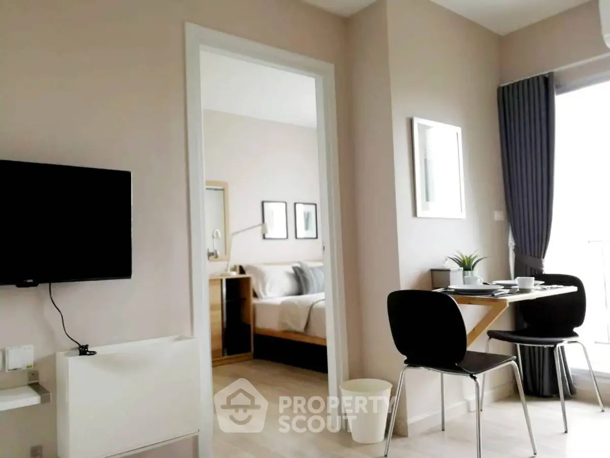 Modern apartment interior with cozy dining area and view into stylish bedroom.