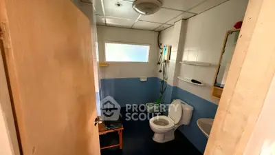Cozy bathroom with blue and white tiles, featuring a toilet, sink, and shower area.