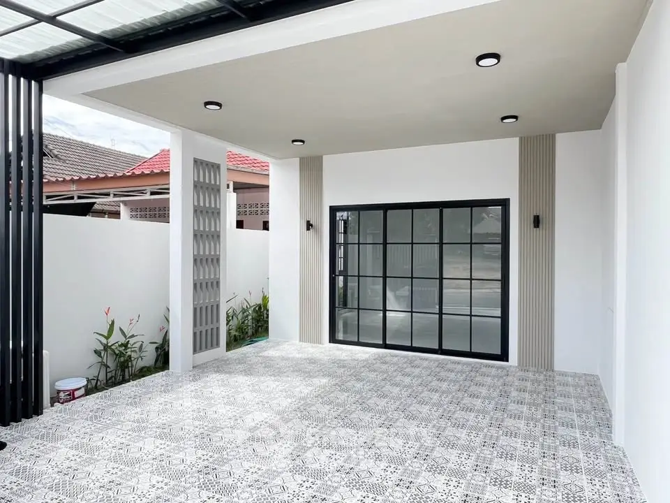 Modern covered parking area with stylish tile flooring and sleek glass doors