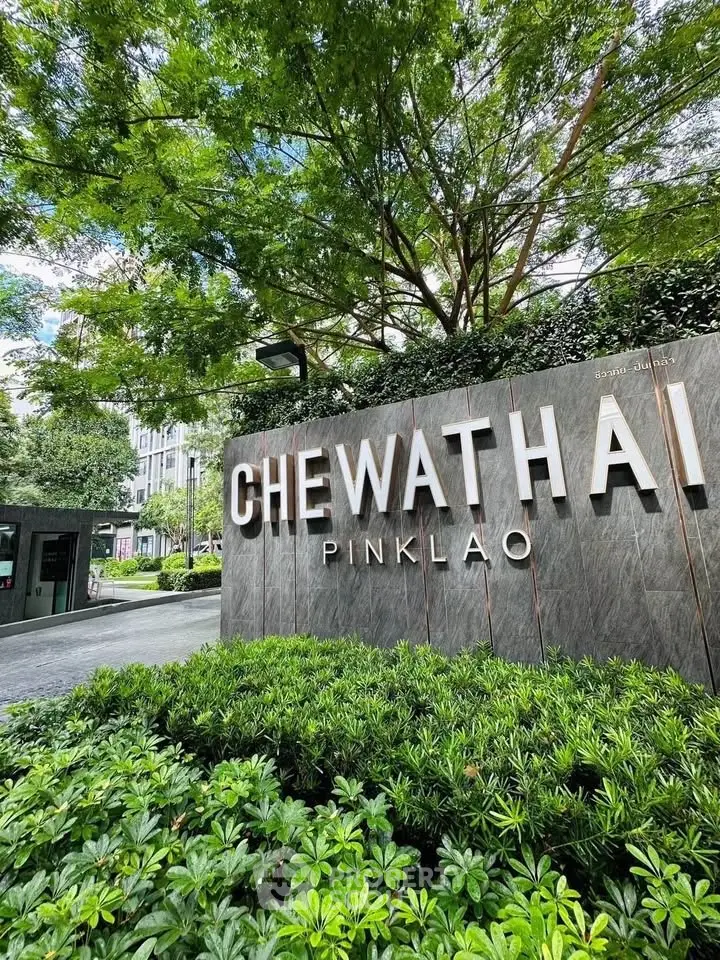 Modern entrance of Chewathai Pinklao with lush greenery and sleek signage.