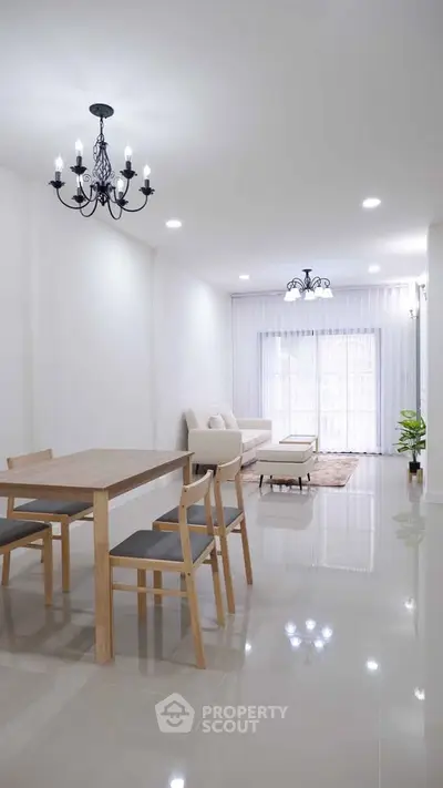 Spacious modern living room with elegant chandelier and natural light