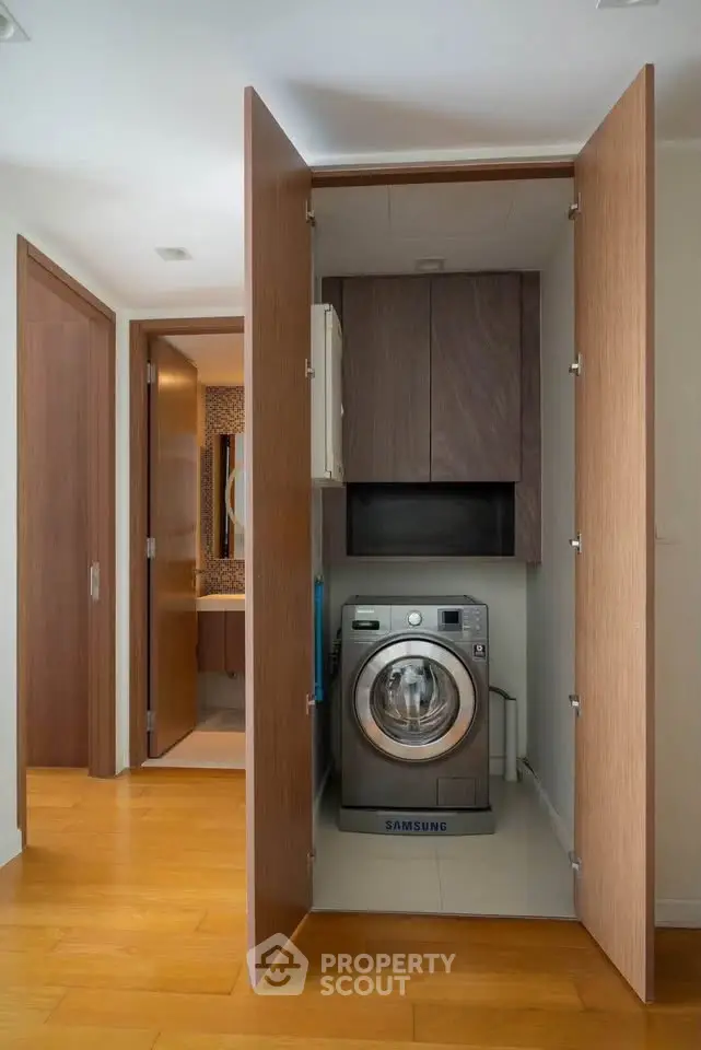 Modern apartment with built-in laundry area featuring a Samsung washing machine.