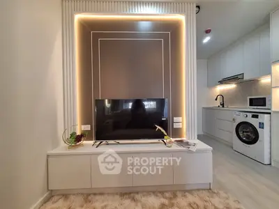 Modern living room with sleek TV setup and stylish kitchen appliances